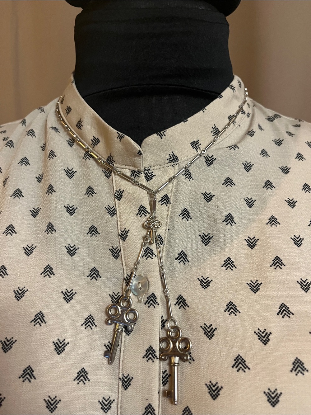 Silver bar necklace with key pendants.